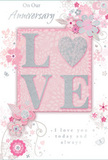 This anniversary card offers a gentle, intimate tribute to enduring romance, as soft and quiet as an evening walk through Holland Park's gardens. At its centre is the word LOVE, raised from the surface so it feels beautifully tactile, each letter outlined with fine glitter that shimmers in blush pink and silver. The O becomes a delicate heart, slightly more textured and shimmering like a tiny keepsake, drawing the eye and inviting touch. Around this central word, pale blooms unfold in shades of blush, mauve, and soft ivory, their petals painted with an almost watercolour softness. Slender vines and swirls ripple outward, giving a sense of movement comparable to the breeze through the park's flower beds in late spring. Small flourishes-tiny petals, spirals, and near-invisible butterflies-add hints of playfulness without disturbing the card's serene mood. The background is a powder-pink wash with silvery grey shadows that lend depth and calm. Elegant scripts spell out On Our Anniversary and I love you today and always, the lettering refined but heartfelt, echoing the quiet promises shared over years of life together in nearby streets and squares. The card feels like a carefully composed arrangement you might collect from a trusted Holland Park florist for same-day delivery, its visual fragrance soft and lingering, making it an ideal keepsake to accompany a bouquet on a shared milestone.